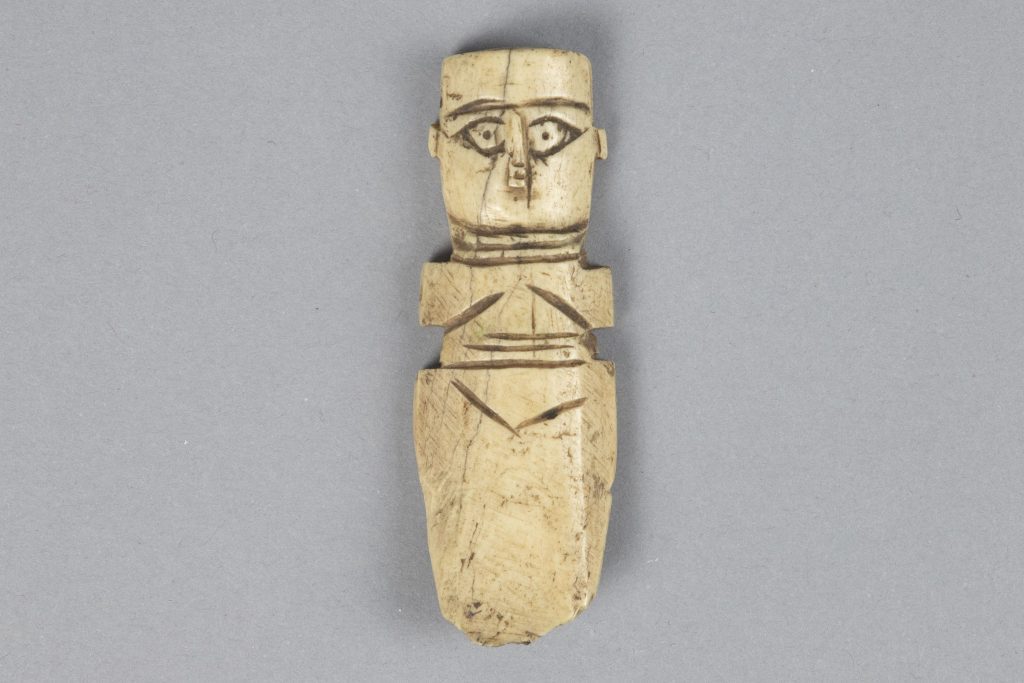 Islamic Egyptian bone doll carved into the shape of a woman with holes in the shoulders for attached arms.