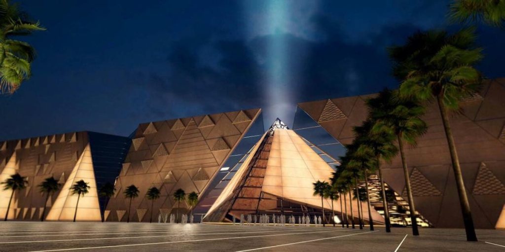 Image of the exterior of the Grand Egyptian Museum illuminated at night.