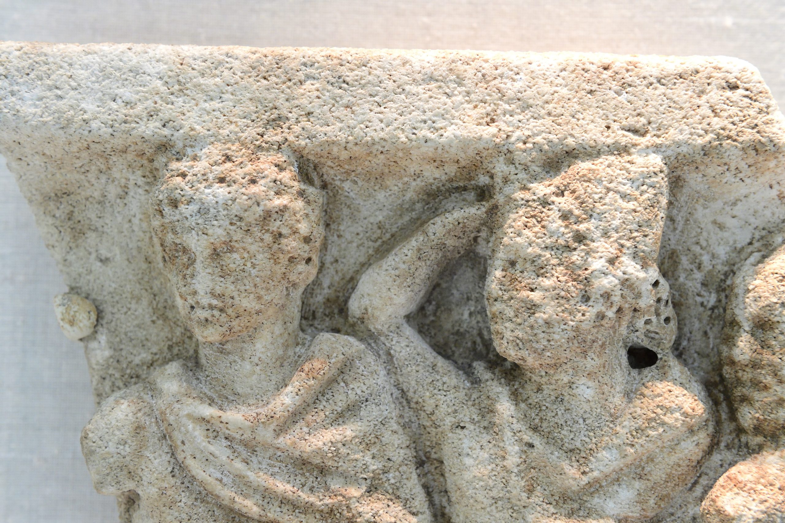 Closeup image of a marble relief with three diners.