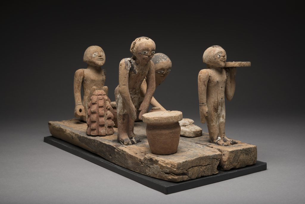 Wooden ancient Egyptian model with four figures baking bread and brewing beer.