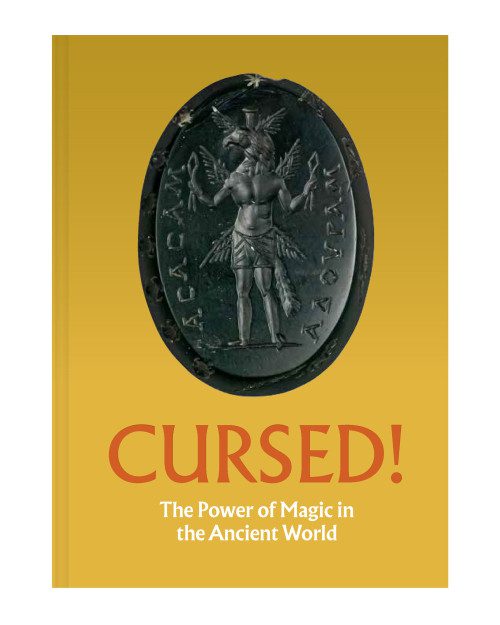 Yellow exhibition catalog cover with an image of an intaglio gem and the title "CURSED!"
