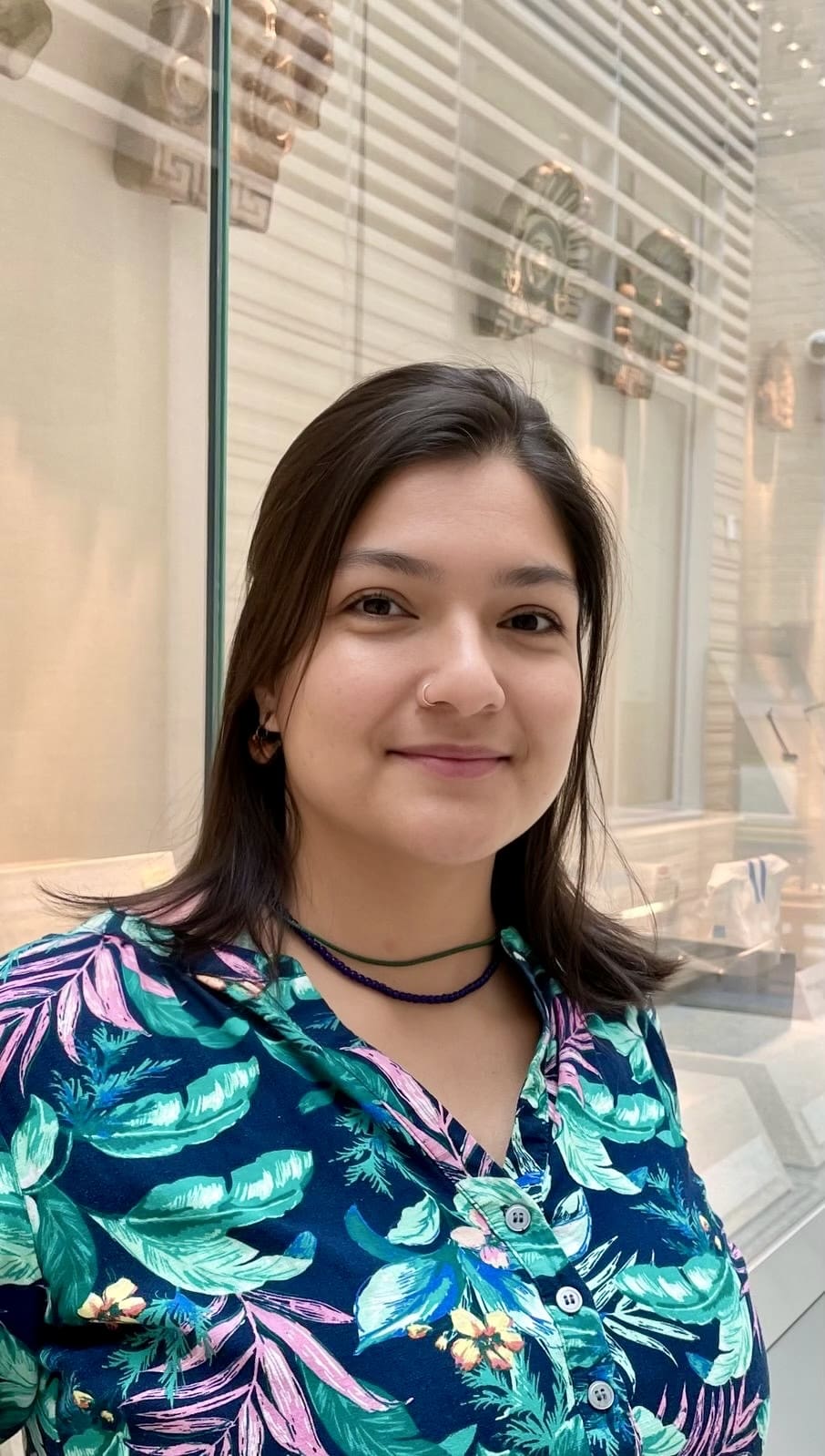 Headshot of Danute Perez, Collections Manager, in front of exhibition case.